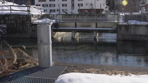 Water flowing through a small dam in winter alpine village Video stock 340836946