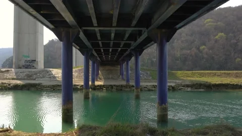 Water flowing under small iron bridge Stock Footage 178133576