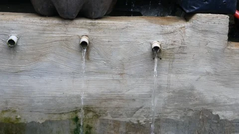 Water flowing from the wall through the fish pond pipe Stock Footage 300860513