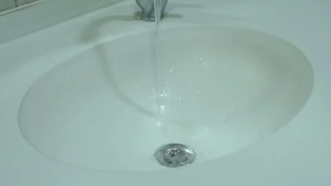 Water-flowing-into-white-ceramic-sink-high-angle Stock Footage 344943901
