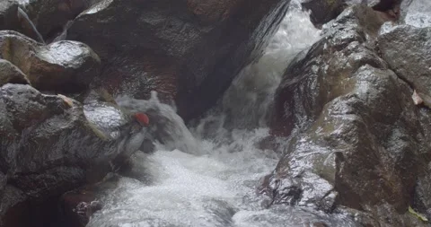 The water that flows against the rock is like a small waterfall. Stock Footage 223383235