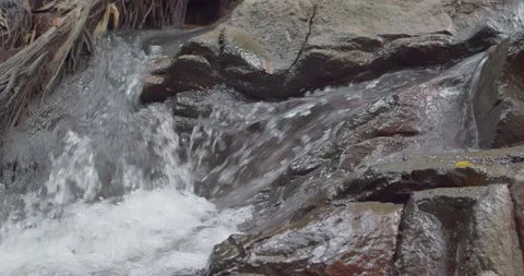 The water that flows against the rock is like a small waterfall. Stock Footage 223383261