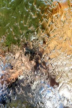Water flows along the wall of the mirror, vertical abstract background, shiny Stock Photos