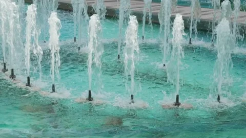Water flows and splashes from cylindrical fountain nozzles 스톡 동영상 276108527