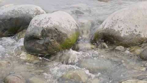 Water flows between large rocks in mountain river Stock Footage 276208023