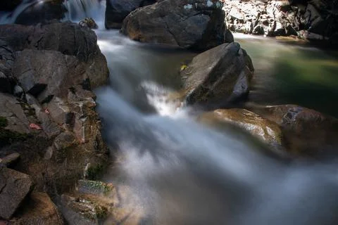 Water flows between rocks Stock Photos