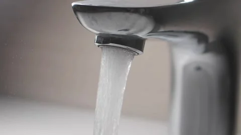 Water flows from a chrome faucet in a kitchen sink Stock Footage 329263248