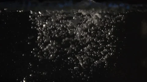 The water flows closeup and lots of bubbles on a black background in slow motion Stock Footage 73354765