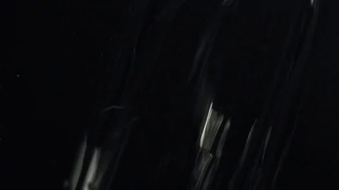 The water flows closeup on black background in slow motion Stock-Footage 73354793