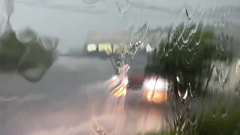 Water flows down a bus window with trees and open land visible beyond the rain c Stock Footage 340150206