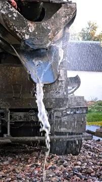 Water flows down the chute of a concrete mixer. Washes the concrete mixer after Stock Photos