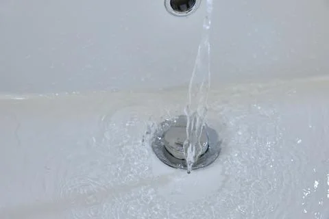 Water Flows Down The Drain In A White Sink Stock Photos