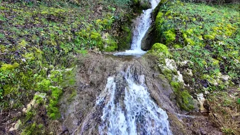 Water flows down in the form of a small waterfall Stock Footage 314907417