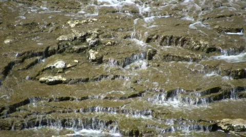 Water flows down the jagged rocks, creating waterfalls (High Definition) Stock Footage 365092