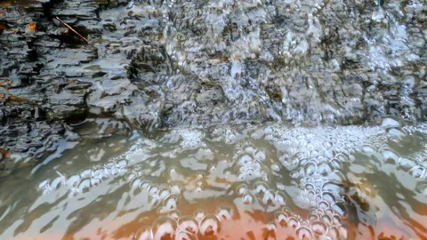 Water flows down from the mountain and sharpens the stones. Stock Footage 151952369