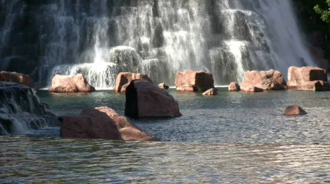 Water flows down rock wall amidst landscaped pond (High Definition) Stock Footage 365262