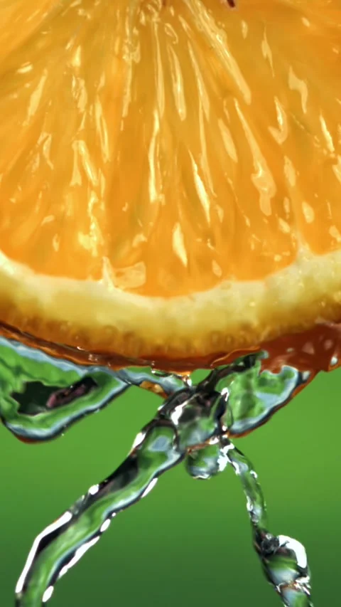 Water flows down from a round slice of orange. Filmed on a high-speed camera at Stock Footage 335378326