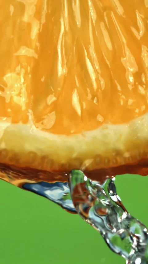 Water flows down from a round slice of orange. Filmed on a high-speed camera at Stock Footage 335381743