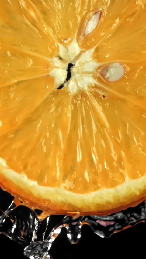Water flows down from a round slice of orange. Filmed on a high-speed camera at Stock Footage 335381898