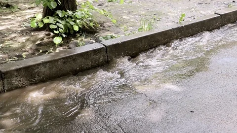 Water flows down the sidewalk after the rain Stock Footage 125285494