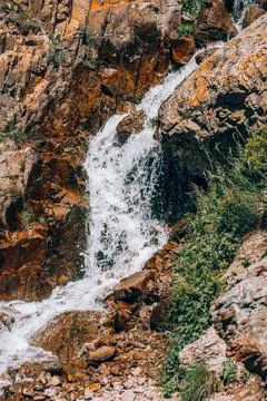 Water flows down from the slopes of the mountains. Small waterfall Stock Photos