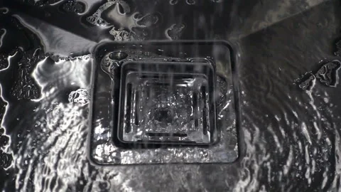 Water flows down in slow motion into a metal sink Stock Footage 141332342