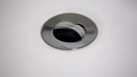 Water flows into the drain in the white clean washbasin Stock Footage 74759031
