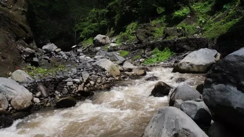 Water flows fast in a rocky river Stock Footage 260765765