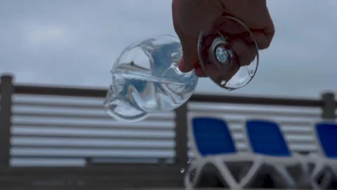 Water flows into a glass next to the pool in slow motion. Healthy lifestyle. Stock Footage 155224706