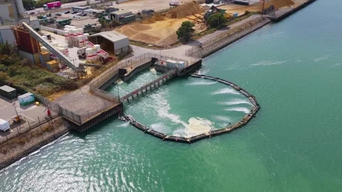 Water flows into the green harbor basin from an industrial facility located at Vídeos de archivo 346881565