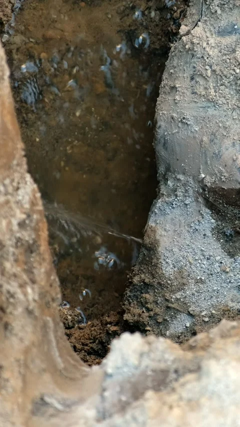 Water flows from the hole rusty pipes. Repair of old water pipes. Stock Footage 285706403