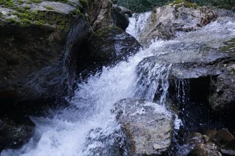 Water flows into a mountain river Stock Photos