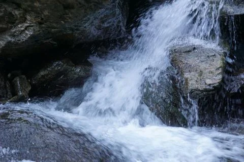 Water flows into a mountain river Stock Photos