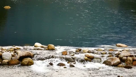 Water flows from the mountains, through the Weir came to the brook in the vil Stock Footage 77154551