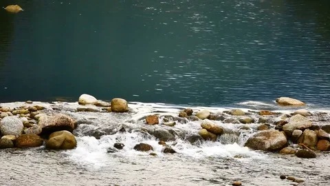 Water flows from the mountains, through the Weir came to the brook in the vil Vídeos de archivo 77154826