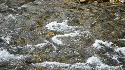Water flows from the mountains, through the Weir came to the brook in the vil Video stock 77154916