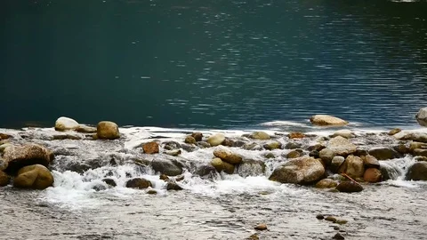 Water flows from the mountains, through the Weir came to the brook in the vil Stock Footage 77155172