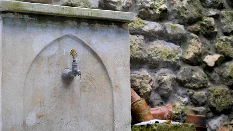 Water flows from an old stone crane in oriental style Stock Footage 124689242