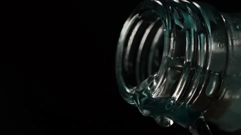 Water flows out of the bottle on a black background to the last drop. Stock Footage 172568440