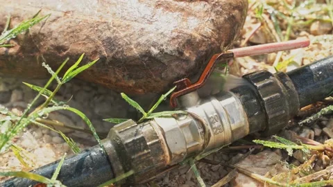 Water flows out of the metal connecting joint between the rubber hoses with Stock Footage 211893960