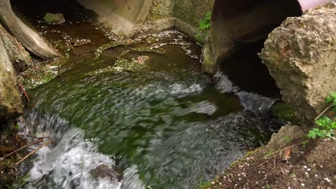 Water flows out of the pipe into the gutter. Stock Footage 153548893