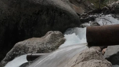 Water flows out of the rusty pipes of the mountain river 스톡 동영상 124668188