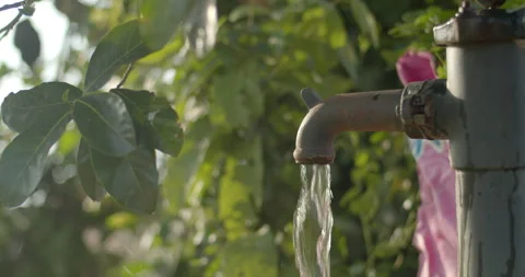 Water flows out of the well head.Pump water up from underground. Stock Footage 306246438