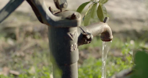 Water flows out of the well head.Pump water up from underground. Stock Footage 306272735