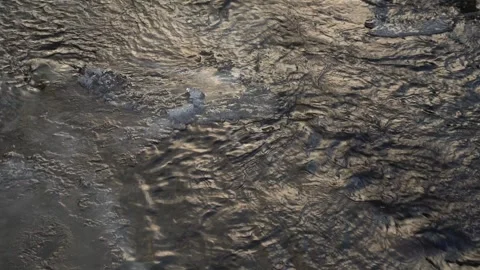 Water flows over ice in a winter setting with snow covering the ground Stock Footage 327590984