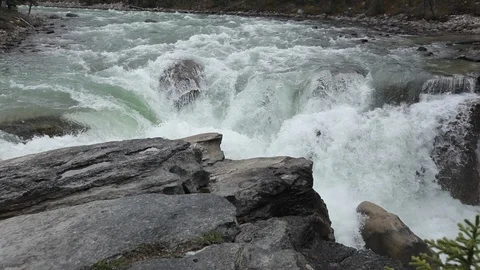 Water flows over river rapids in forested valley in Alberta Stock Footage 90841425