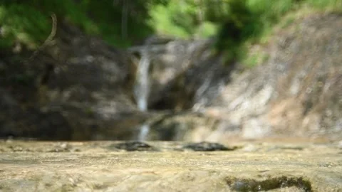 Water flows over rocks and creates bubbles (slow motion, bokeh) Stock Footage 212746711