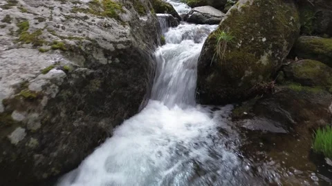 Water flows over the rocks as the camera moves upstream Stock Footage 270153605