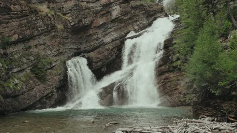 Water flows over rocks at Cameron Falls in Waterton Lakes National Park Stock Footage 327769376