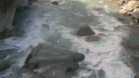 Water flows over the rocks of a river in New Zealand Stock Footage 218418078